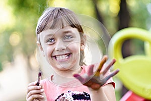 Little girl painting with paintbrush and colorful paints