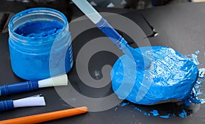 Little girl painting stone with blue paint