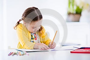 Little girl painting and writing