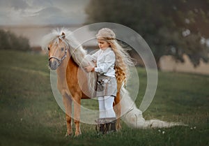 Little girl with palomino miniature horse in summer day