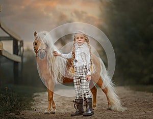 Little girl with palomino miniature horse in summer day