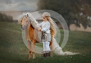 Little girl with palomino miniature horse in summer day photo