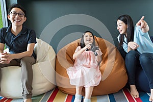 Little girl and parent family playing video game at home.