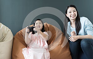 Little girl and parent family playing video game at home.