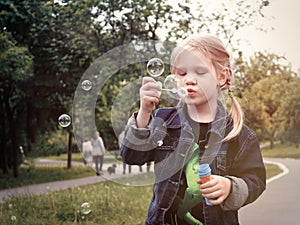 Little girl in Park blow bubbles