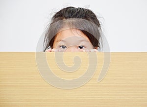 little girl peeking over table.