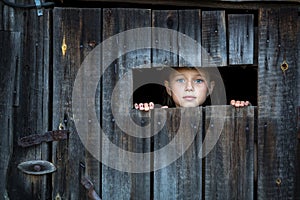 Little girl peeking through from the window at doors.