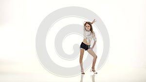 Little girl performs rhythmic dance movements. White background. Slow motion