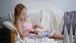 Little Girl Petting Puppy near Christmas Tree