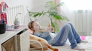 a little girl with a phone in bed. children and smartphone.