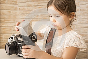 Little girl photographer holding old vintage film photo camera