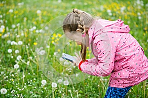 Little girl photographing with her smartphone