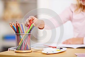 Little girl is picking colored pencils