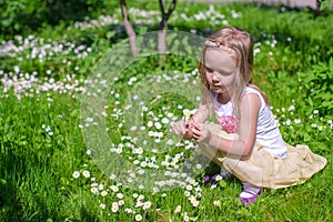 Little girl picking flowers in green glade