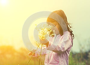 Little girl picking flowers on the meadow