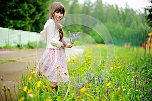 Little girl picking up summer flowers