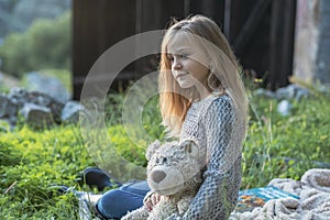 Little girl on a picnic is holding a teddy bear