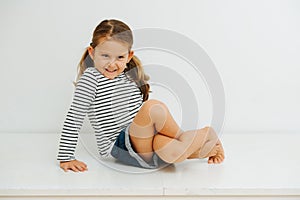 Little girl with pigtails twisting her legs