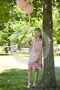 Little girl with pink balllons