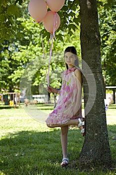 Little girl with pink balllons