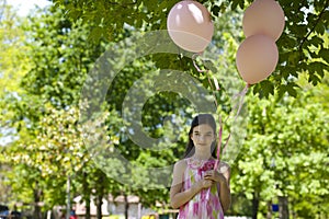 Little girl with pink balllons