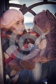 Little girl in a pink beret sits