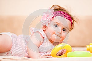 Little girl in pink dress lying on the couch.