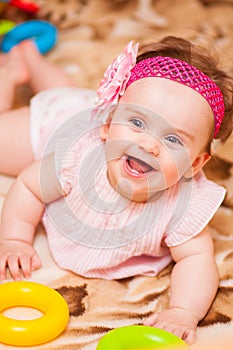 Little girl in pink dress lying on the couch.