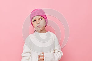 little girl pink hat on her head posing pink background