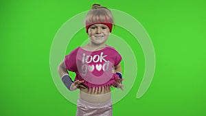 Little girl in pink sportswear tells something and showing thumb up gesture. Chroma key background