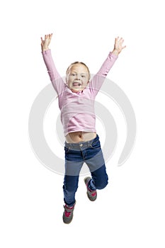 A little girl in a pink sweater and jeans joyfully jumps. Isolated over white background.