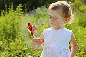 Little girl with pinwheel standing in grass