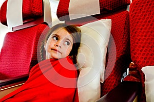 Little girl in a plane scared to fly - flying phobia photo