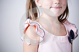 Little girl with plaster on shoulder, vaccination