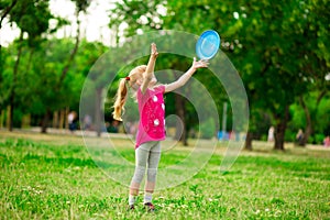 Little girl play with flying disk in motion