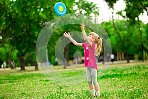 Little girl play with flying disk in motion