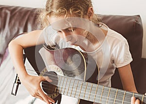 Little girl play guitar.