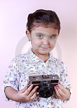 Little girl play with old camera