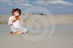 Little girl play panpipe in desert