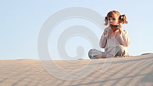 Little girl play panpipe in desert