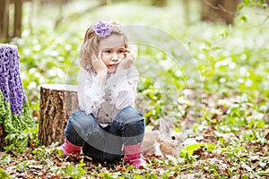 Little girl  play with real rabbit in the garden. Cute child at Easter egg hunt with  pet bunny. Spring outdoor fun for kids with