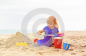 Little girl play with sand on beach