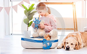 Little girl play with sea ship with golden retriever dog