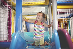 Little girl in playground. Happy little girl sitting on toboggan