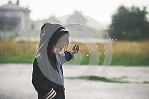 Little girl playing alone outside in bad weather