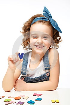 Little girl playing in the alphabet. Shows the letter V.