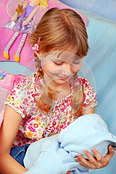 Little girl playing with baby doll