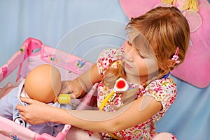 Little girl playing with baby doll