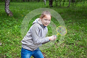 Little girl playing badminton on the street photo