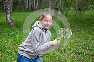 Little girl playing badminton on the street